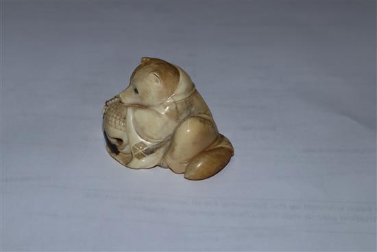 A Japanese Meiji period carved ivory netsuke of a fox cub on a cushion, with inset eyes 3.5cm high